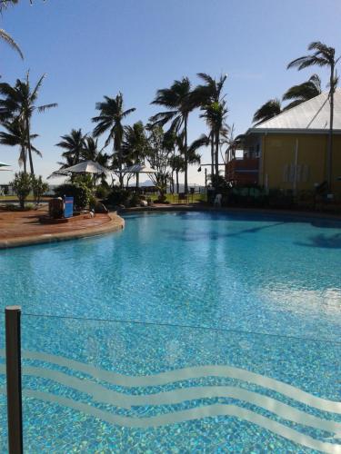 una gran piscina con palmeras en el fondo en Apartment in Dolphin Heads, en Eimeo