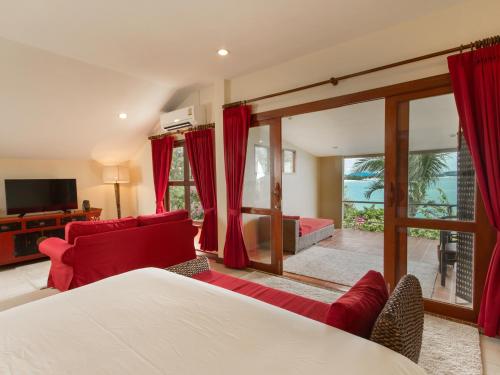 a bedroom with a bed and a living room at Boujis Boutique Resort in Chaweng Noi Beach