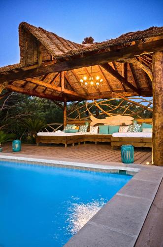 une pergola en bois à côté d'une piscine dans l'établissement Villa Reve de Sud, aux Issambres