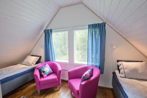 a room with two chairs and a bed and a window at Villa Aurela in Rovaniemi