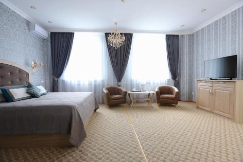 a bedroom with a bed and a flat screen tv at Hotel Bahetle in Ekibastuz