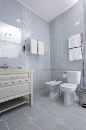 a bathroom with a toilet and a sink at Hotel Bahetle in Ekibastuz