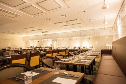 a restaurant with wooden tables and yellow chairs at Summit Hotel Seoul Dongdaemun in Seoul