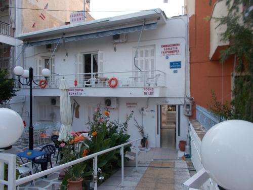 a white building with a balcony in a city at Karampela Rooms in Loutra Edipsou