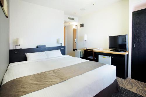 a bedroom with a bed and a desk and a television at Sapporo Tokyu REI Hotel in Sapporo