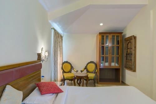 a bedroom with a bed and a table and chairs at Ramsukh Resorts and Spa in Mahabaleshwar