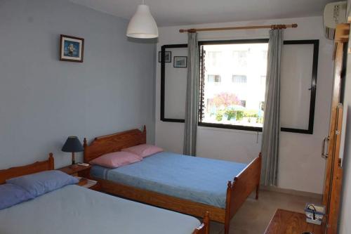 a bedroom with two beds and a window at Kaparris Apartment in Paralimni