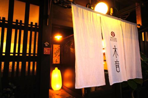 Ein Schild hängt an einem Zaun vor einem Gebäude. in der Unterkunft Guesthouse Kioto in Kyoto