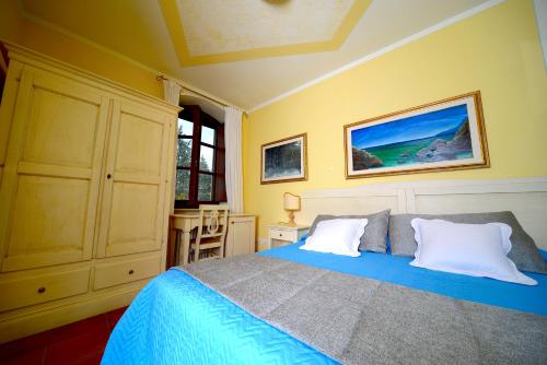 a bedroom with a blue bed and yellow walls at Residenze L'Uncinaia Holiday House in Perugia