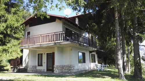 una piccola casa bianca con balcone e alberi di Casa Giuliana a Tremosine Sul Garda