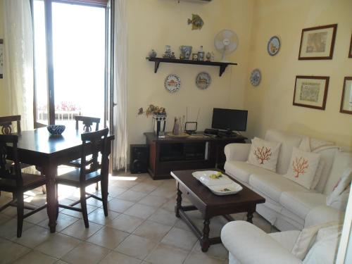 ein Wohnzimmer mit einem Sofa und einem Tisch in der Unterkunft Casa vistamare Alfeo in Syrakus