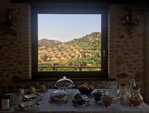 a table with a window with a view of a field at Il casolare in Borgia