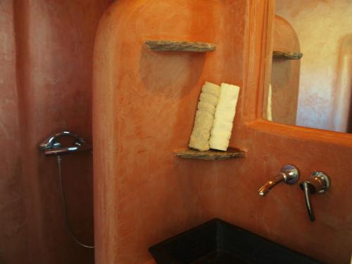 y baño con lavabo, espejo y toallas. en Almyra Yellow Villa en Kithnos