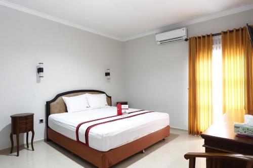 a bedroom with a large bed and a window at RedDoorz Plus near Adisucipto Airport 2 in Yogyakarta