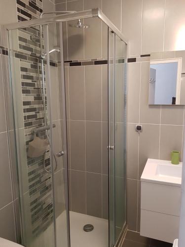 une salle de bain avec une douche en verre et un lavabo dans l'établissement Etoile De Mer, à Menton