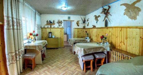 a room with four tables and chairs in a room at EniRest in Karakol