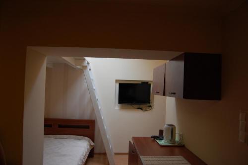 a small room with a bed and a tv at Pokoje Nad Arkadami in Zamość