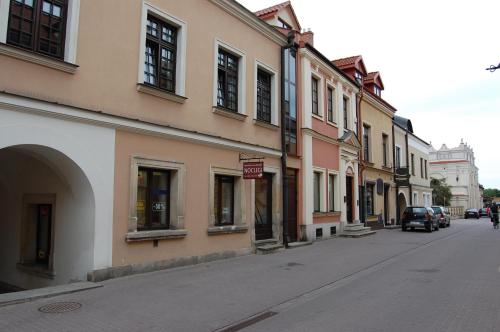 ザモシチにあるPokoje Nad Arkadamiの路上駐車の建物