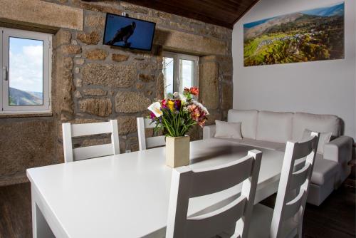 a dining room with a white table and chairs at Casas Peralta - Amarela in Arouca