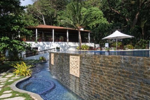a swimming pool with a brick wall next to a resort at Club Punta Fuego in Nasugbu