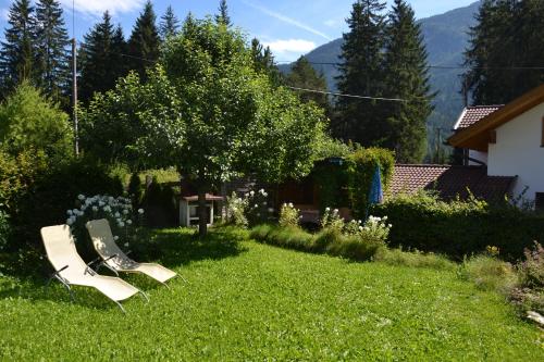 une cour avec deux bancs dans l'herbe dans l'établissement Ferienhaus Heidi, à Piller
