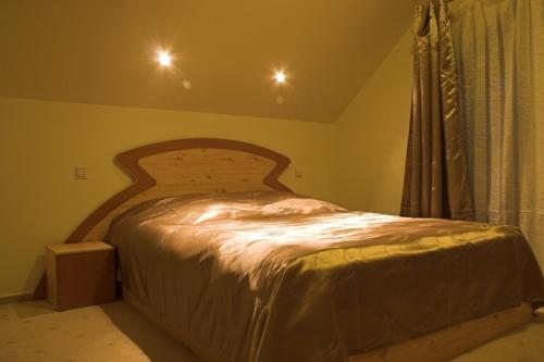 シナイアにあるPensiunea Turistica Delmonte Holidayのベッドルーム1室(木製ヘッドボード付きのベッド1台付)