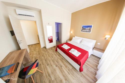 una camera d'albergo con un letto con una coperta rossa di Quinto Stabile Rooms&Suite a Palermo
