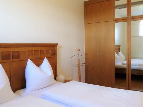 a bedroom with a bed with white sheets and a mirror at Ferienhaus Bauhaus in Königsberg in Bayern