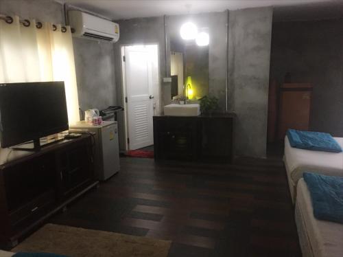 una camera da letto con televisore e un bagno con lavandino di Crescent Bay Resort a Ko Samed