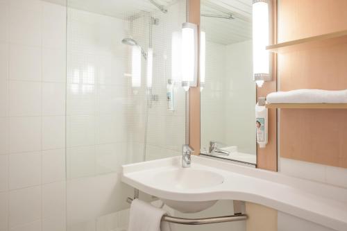 a white bathroom with a sink and a shower at ibis Maine Montparnasse in Paris