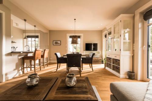 a living room with a table and a kitchen at Kamphof Usedom Ferienanlage in Loddin