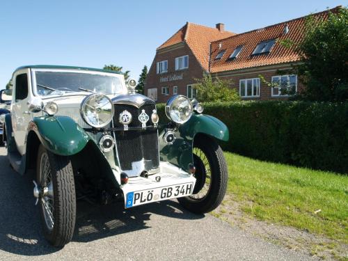an old car parked on the side of a street at Hotel Lolland in Nørreballe