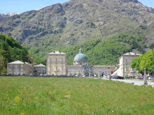 a large building with a hill in front of a mountain at Santuario di Oropa in Biella