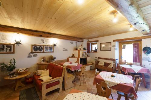 un soggiorno con tavoli, sedie e soffitti in legno di Agritur Manoncin a Daone