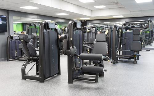 a gym with rows of exercise equipment in it at Village Hotel Birmingham Dudley in Dudley