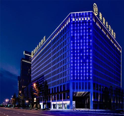 un grande edificio con luci blu sul lato di Qin Huang Yong An Hotel a Chengdu