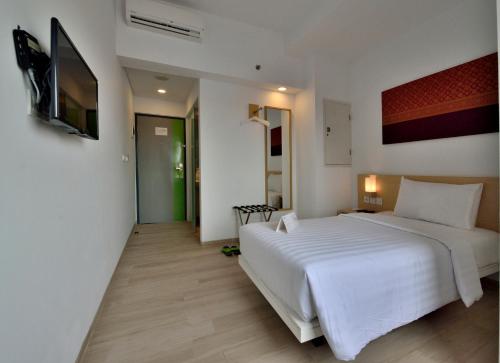 Ένα ή περισσότερα κρεβάτια σε δωμάτιο στο Whiz Hotel Sudirman Pekanbaru