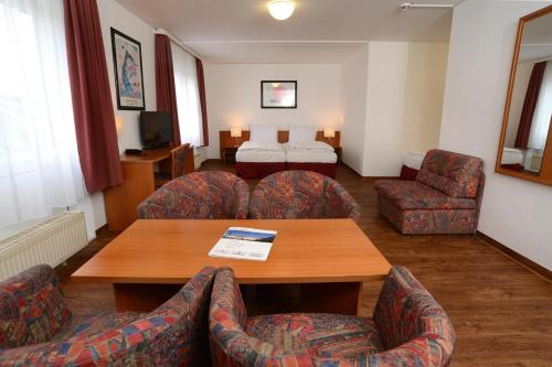 a hotel room with a table and chairs and a bed at Apart Hotel Sehnde in Sehnde