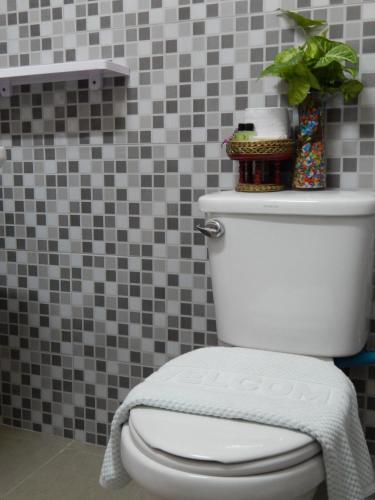 a white toilet in a bathroom with a tile wall at Baan Chanoknunt Resort Pai in Pai