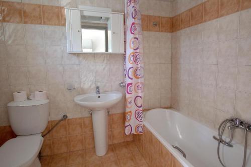 a bathroom with a toilet and a sink and a tub at Pinelopi Apartments in Georgioupolis