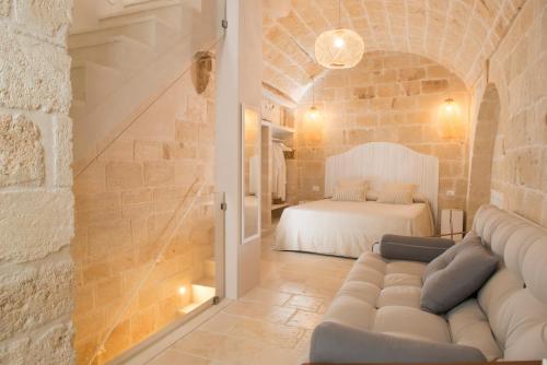 a living room with a couch and a bed at Dimora Madina by MANZONI COLLECTION in Monopoli