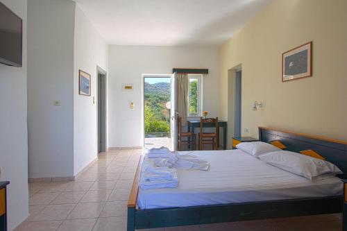 a bedroom with a bed and a door to a patio at Pinelopi Apartments in Georgioupolis