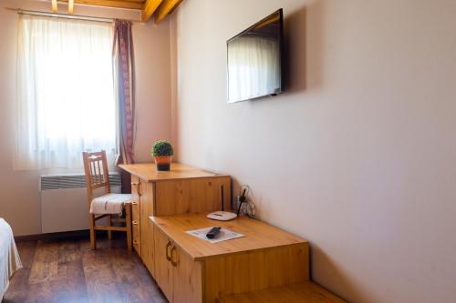 Habitación con escritorio, cama y ventana en Blum Pince - Borozó Vendégház, en Villány