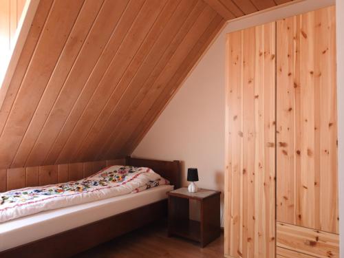 1 dormitorio con cama y techo de madera en Gospodarstwo Kaczynski Ostrołęka, en Wyszel