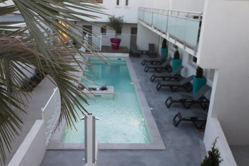 een zwembad in een gebouw met een palmboom bij Résidence Coté Mer in La Grande-Motte