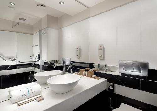 a bathroom with two sinks and a large mirror at Athens Tiare by Mage Hotels in Athens