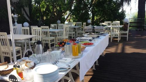 a long table with plates of food on it at Hotel Magllara in Sarandë