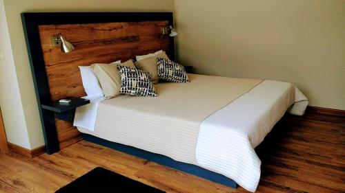 a bedroom with a large bed with a wooden headboard at Casa Do Prado Guesthouse in Vila Real