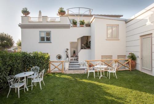 a yard with chairs and tables and a house at Don Antonino Relais in Sorrento