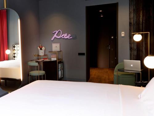 a bedroom with a bed and a room with a laptop at Axel Hotel Madrid - Adults Only in Madrid
